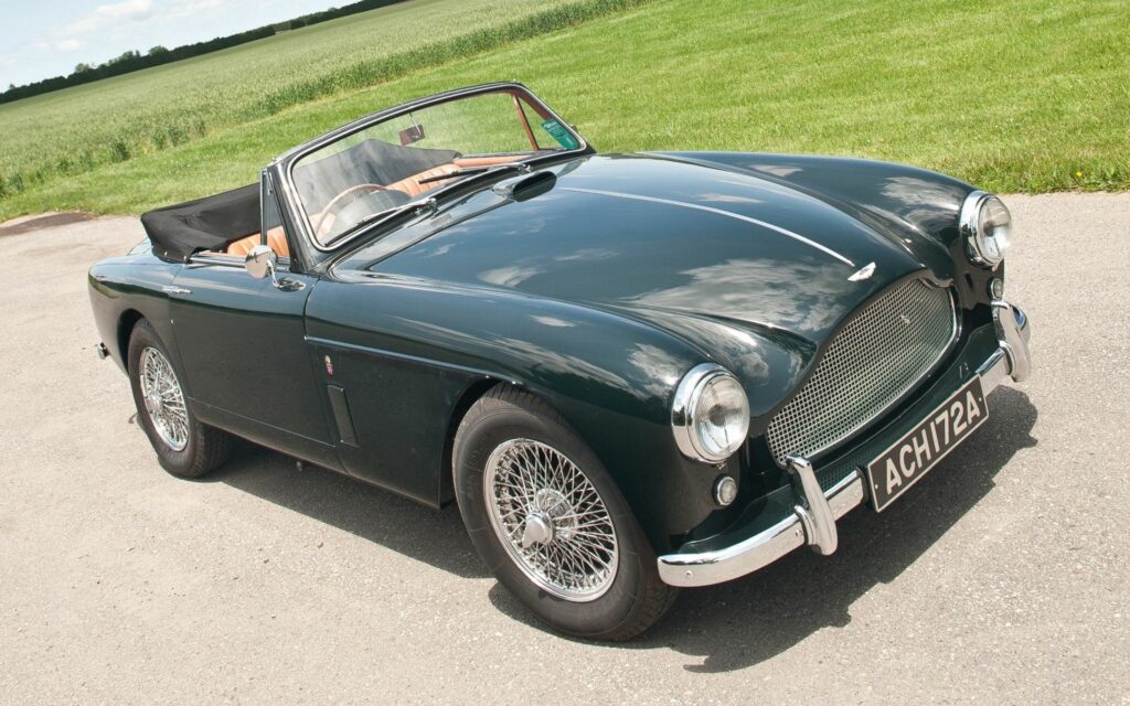 Elegant 1957 Aston Martin Drophead Coupe in Stunning Outdoor Setting Wallpaper