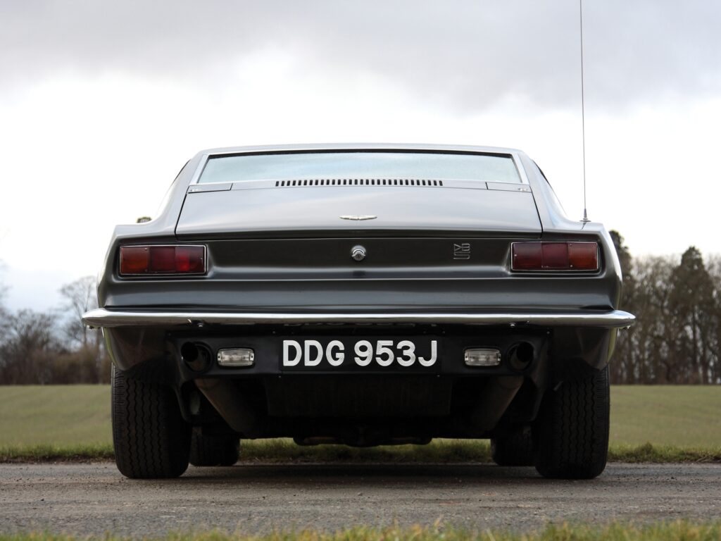 1969 Aston Martin DBS V8 Rear View Wallpaper in Lush Greenery