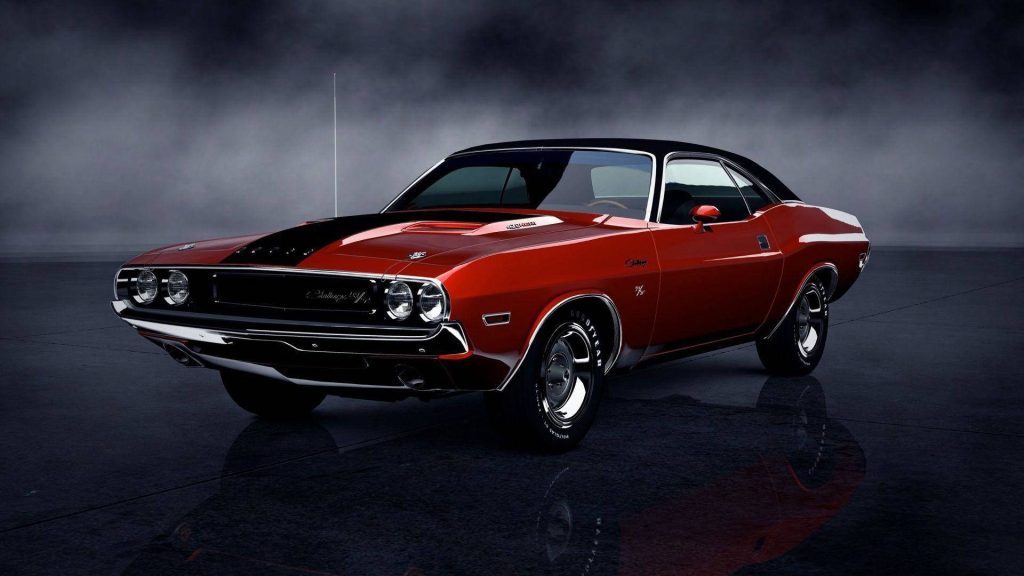Red 1970 Dodge Challenger with black roof in dark studio on reflective floor muscle car wallpaper