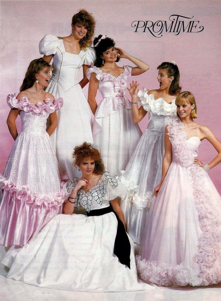 Six women in pastel 80s prom dresses with ruffles and puffy sleeves on pink backdrop Wallpaper