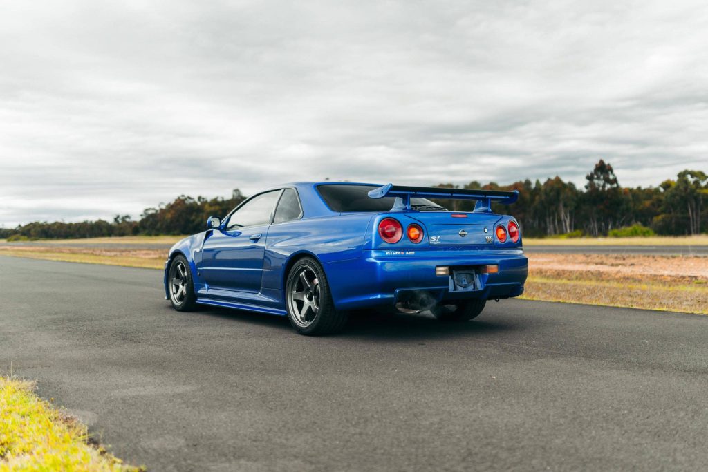 1999 Nissan Skyline GT-R R34 Bayside Blue rear view Nismo S1 badge on open track wallpaper