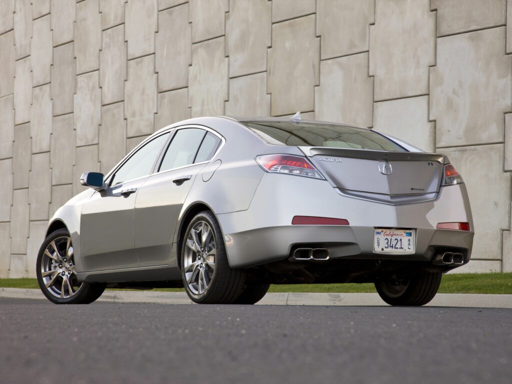 Sleek 2008 Acura TL in Metallic Gray Against Concrete Wall Wallpaper
