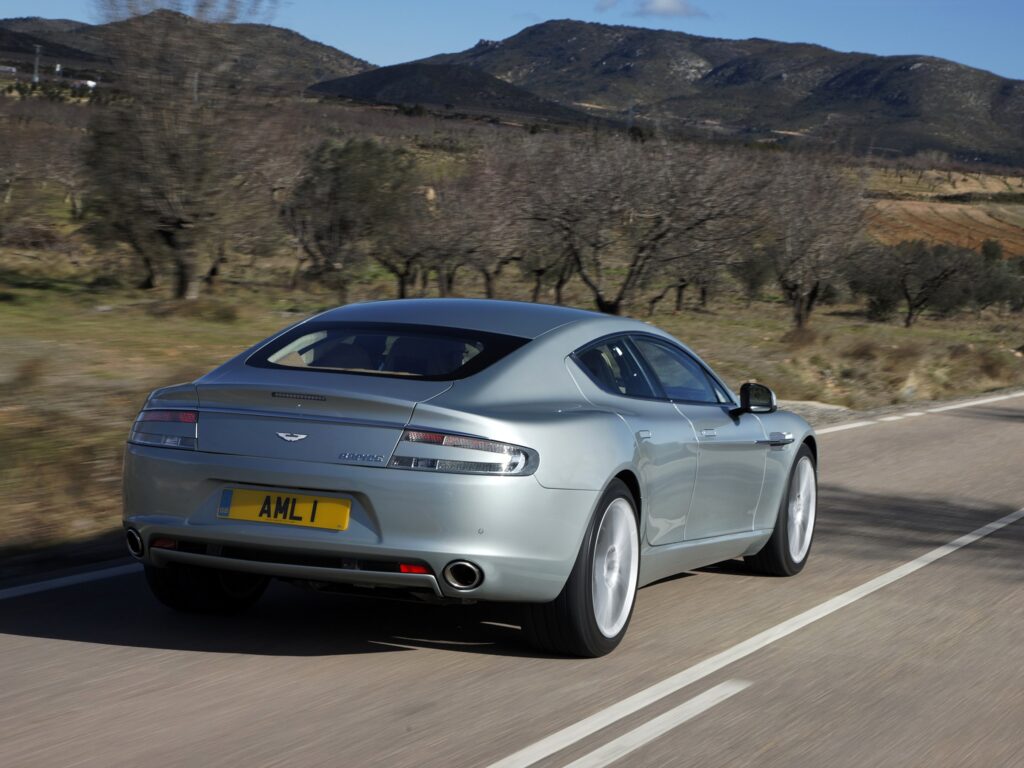 Sleek Silver 2009 Aston Martin Rapide in Scenic Mountain Landscape Wallpaper