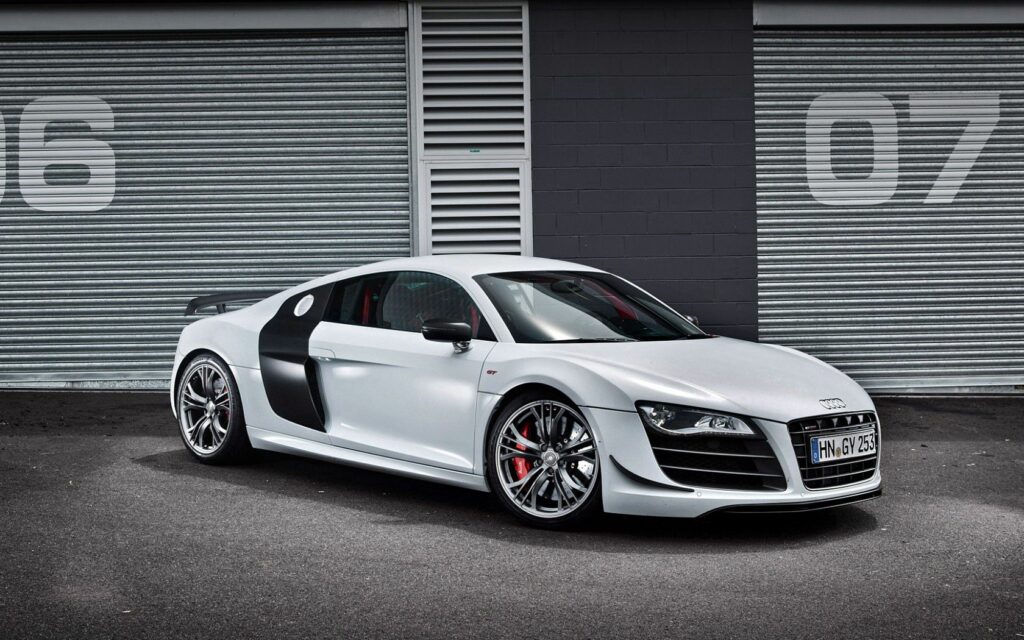Stylish 2010 Audi R8 GT Wallpaper Against Industrial Background