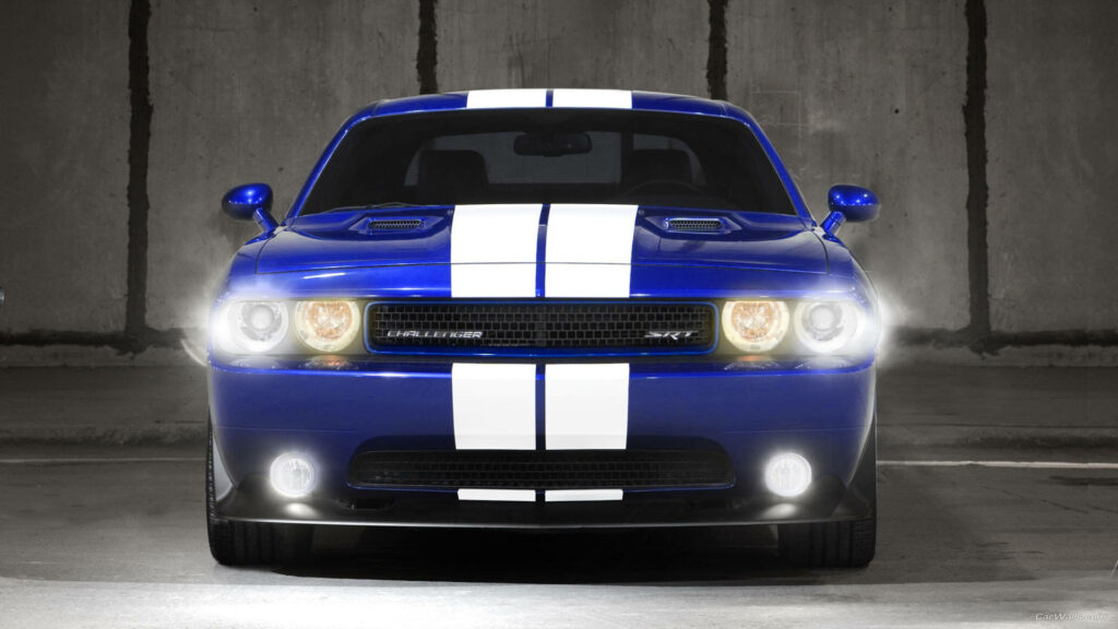 Front view 2012 blue Dodge Challenger with white racing stripes and illuminated headlights urban background Wallpaper