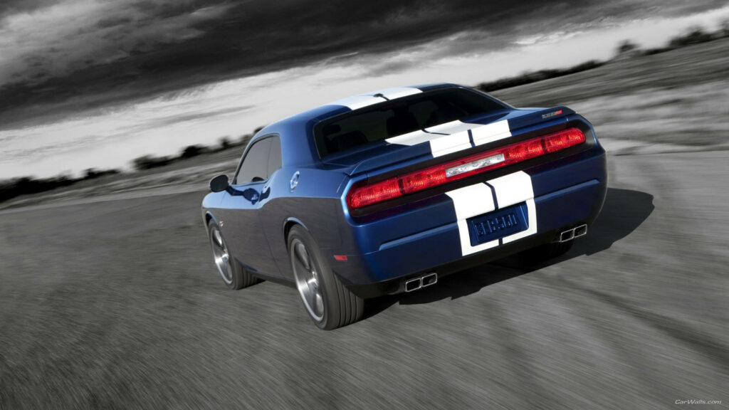 Blue 2012 Dodge Challenger with white racing stripes speeding on winding track under moody sky Wallpaper