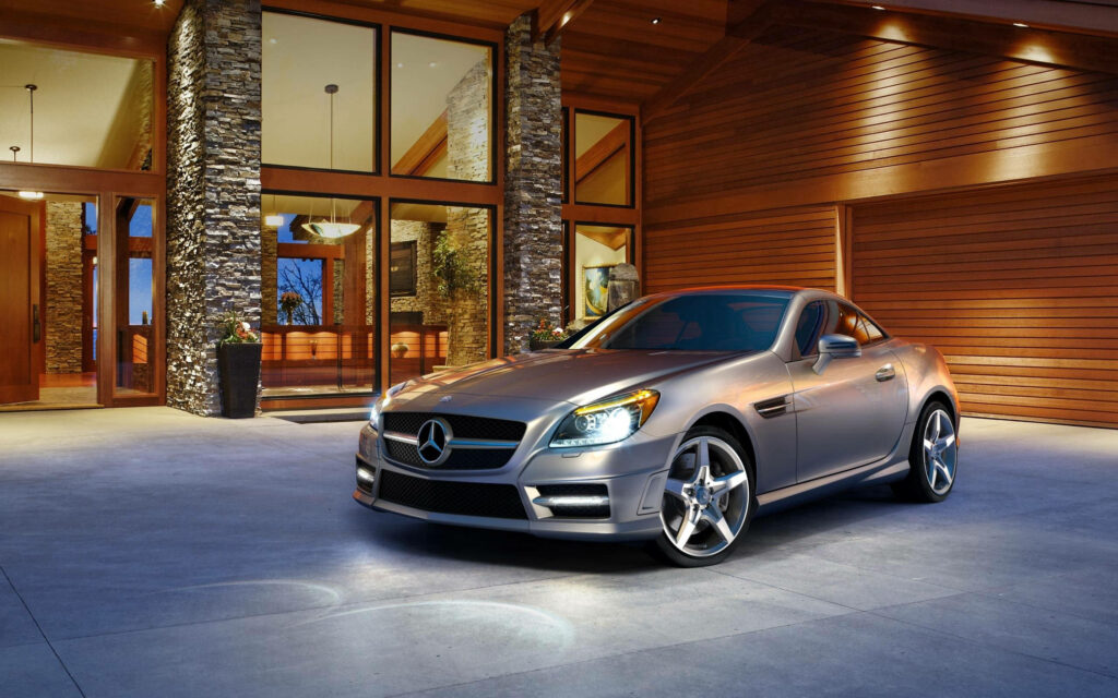 2015 Mercedes-Benz SLK55 AMG silver sporty coupe parked outside modern stylish home at dusk Wallpaper