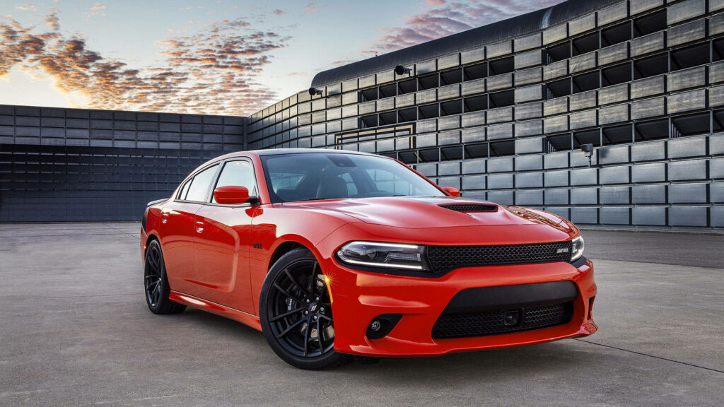 Red 2018 Dodge Charger SRT392 with aggressive grille and black alloy wheels in industrial setting Wallpaper
