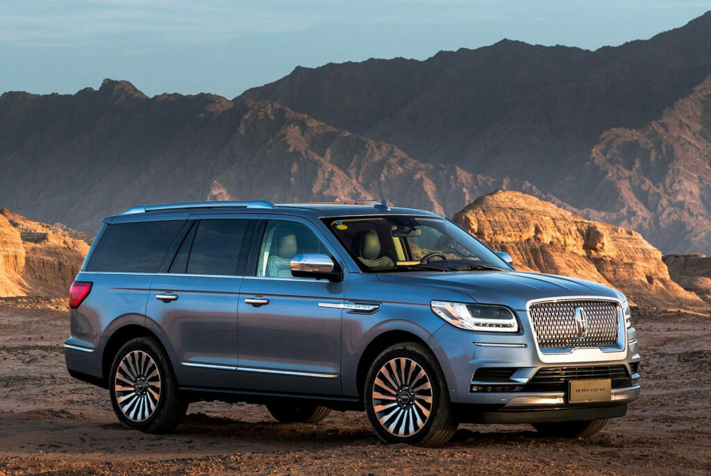 2018 Lincoln Navigator parked on rugged mountain side with rocky terrain and distant peaks Wallpaper