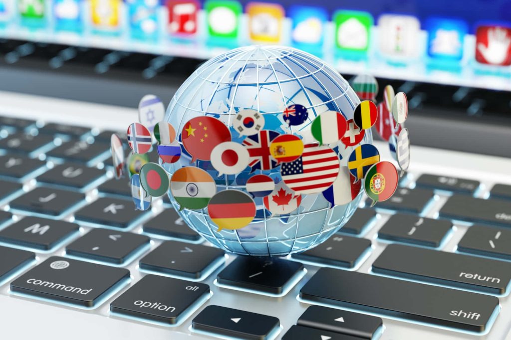 3D wireframe globe with flags in speech bubbles on laptop keyboard representing global translation Wallpaper