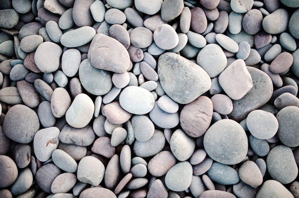 Top-down 4D Ultra HD wallpaper of smooth pale grey and taupe river pebbles for minimalist decor