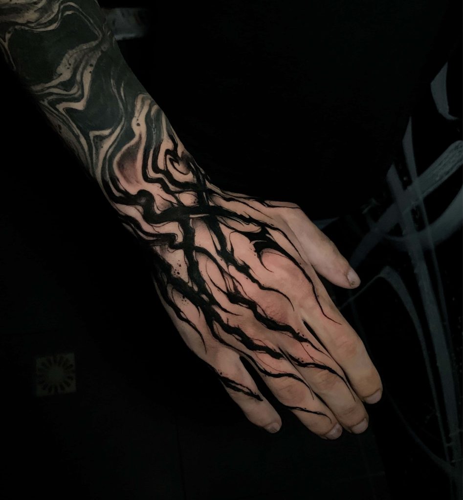 Abstract black ink tattoo on hand with fluid smoke patterns on dark 4K wallpaper background