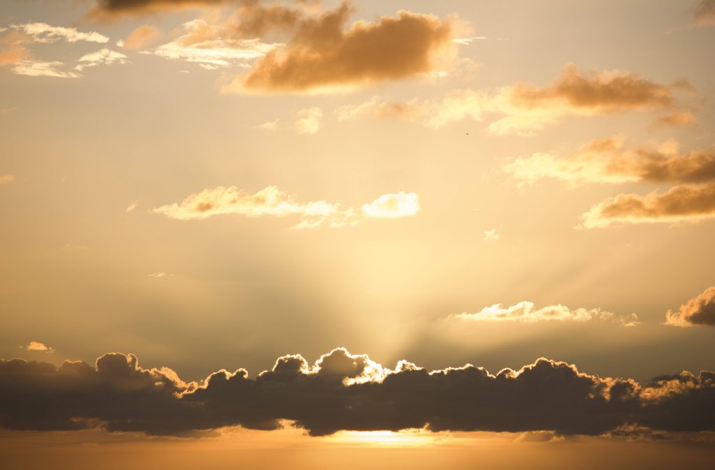 4K sunset sky wallpaper with dramatic clouds and golden rays for serene desktop background