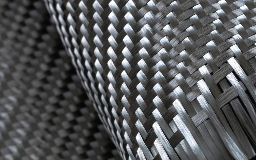 Macro shot of premium carbon fiber texture with metallic sheen on dark blurred background in 4k Wallpaper