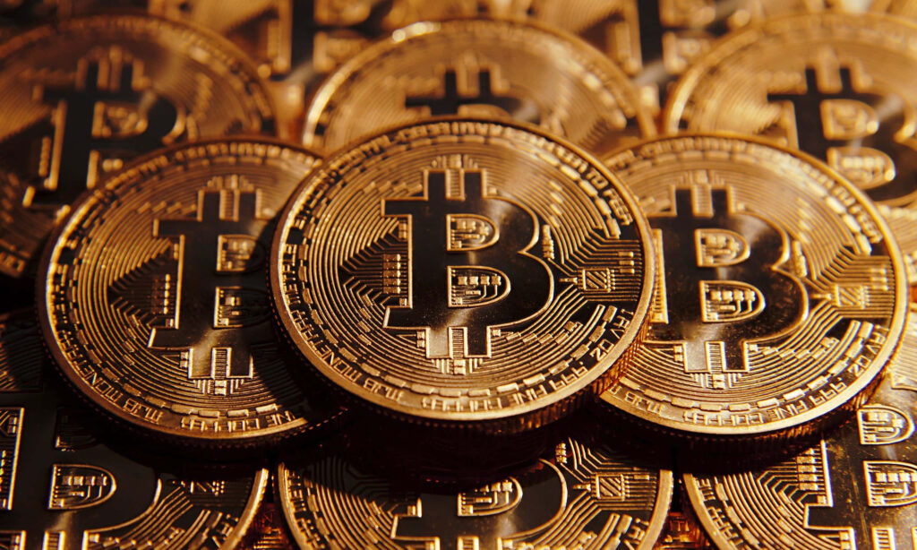 Close-up 4k wallpaper of stacked golden Bitcoins showing detailed metallic texture and design
