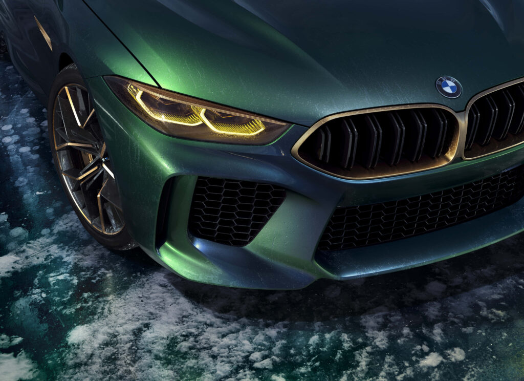 Front view of dark green BMW M8 with aggressive grille sleek headlights on icy textured background Wallpaper