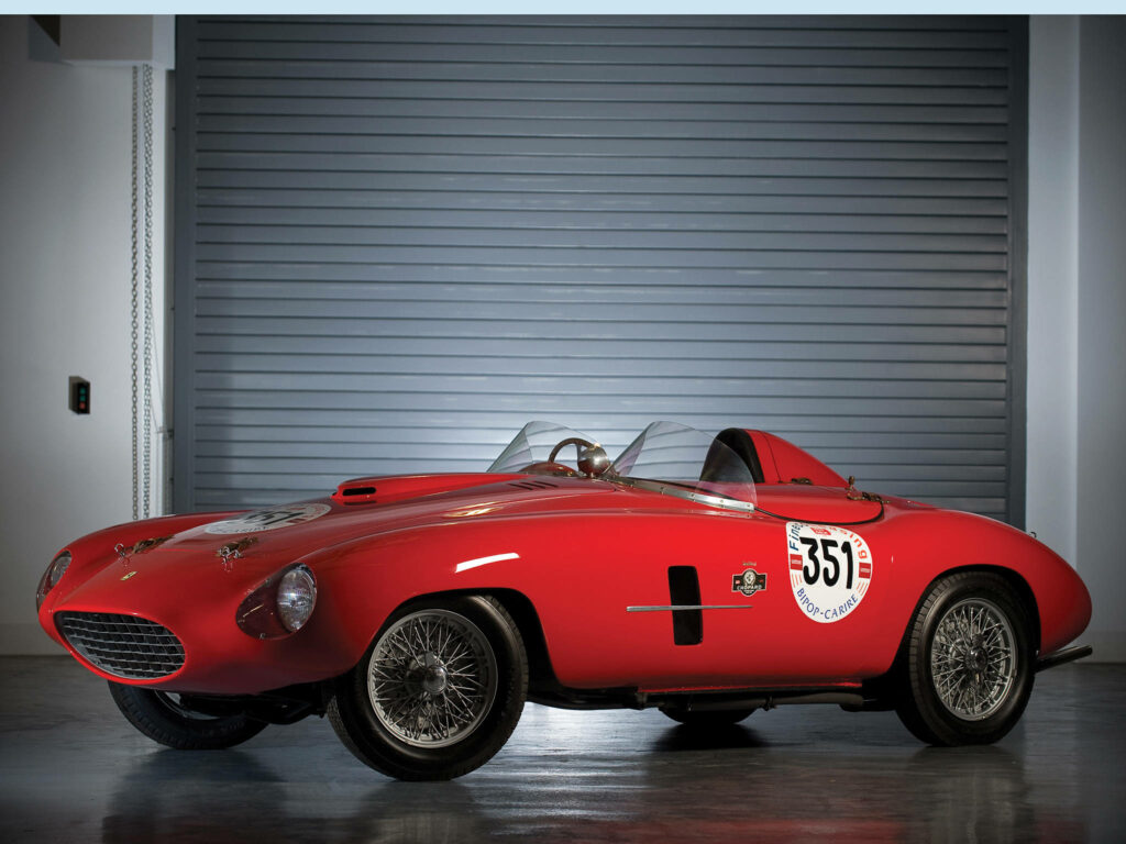 Captivating Illumination: An Exquisite 4k Ferrari 166 MM Racing Car Model Showcased in Radiant Red Shade against a Striking Side-Lit Backdrop Wallpaper