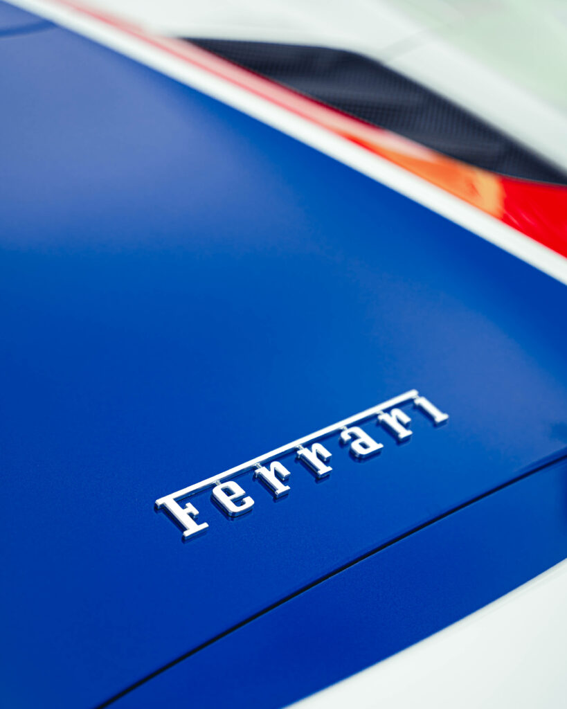 Capturing the Dynamic Essence: An Elevated View of the Striking 4K Ferrari Logo Adorning the F140 Sports Car Model in Blue Elegance Wallpaper