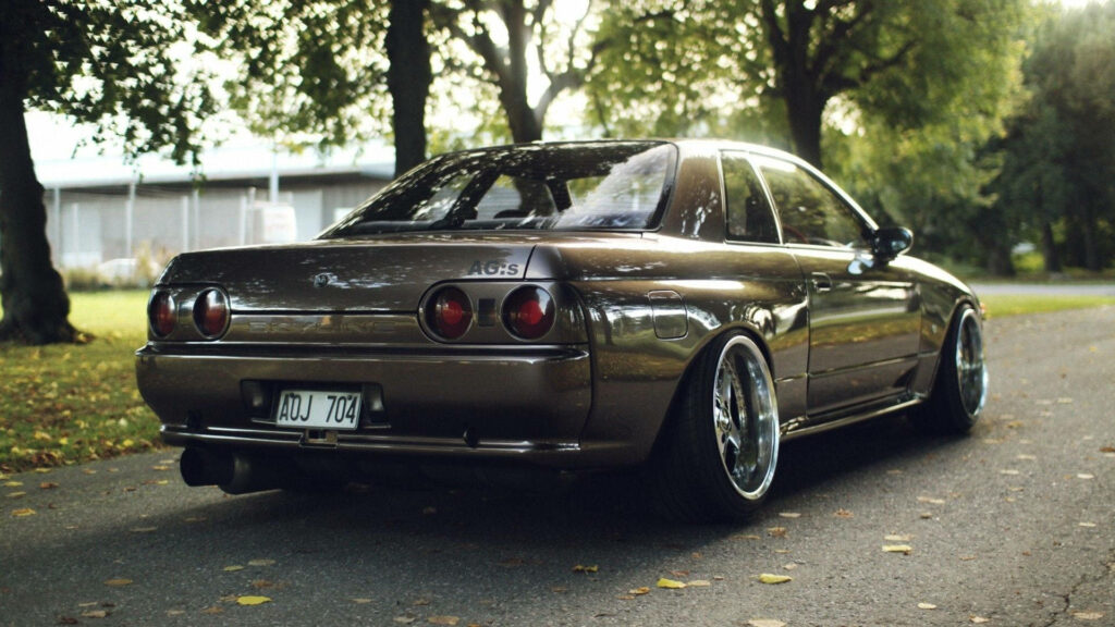 Enchanting Journey: 4K JDM Nissan Skyline Roaming through Serene Green Forest Wallpaper