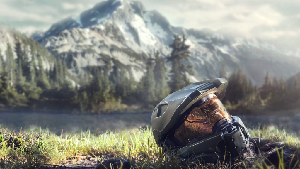 4K Master Chief helmet on grass with forest lake and snow-capped mountains cinematic lighting Wallpaper