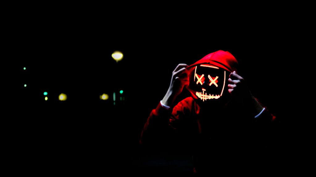 4K red neon wallpaper of mysterious figure in LED Purge mask with X-eyes on black background
