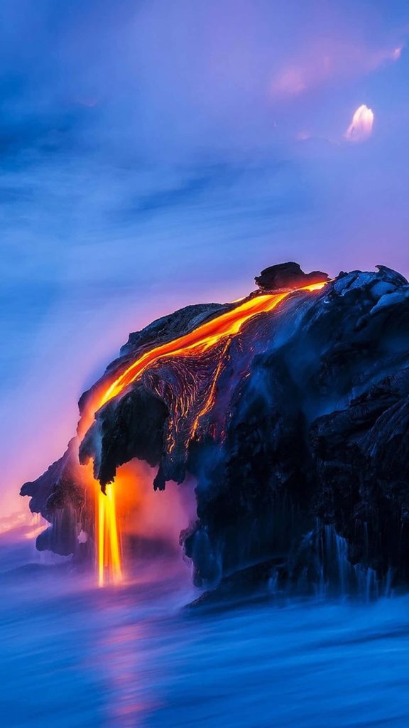 Vivid orange lava flowing down volcanic cliff into ocean under twilight sky 4k phone wallpaper