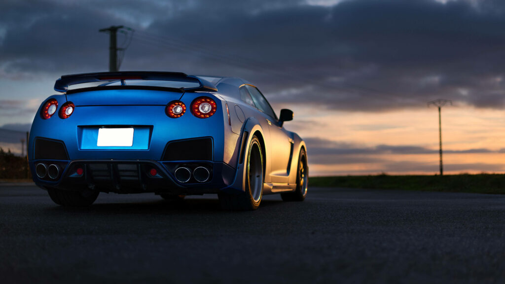 4K Matte Blue Nissan GT-R Wallpaper Under Dramatic Sunset Sky