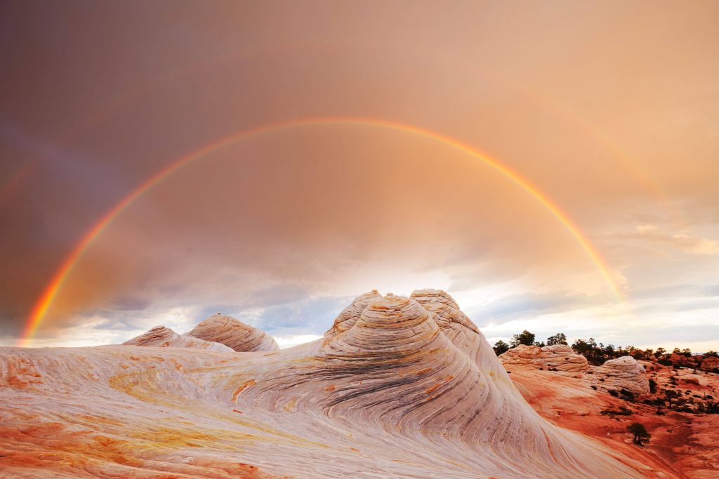 Double rainbow over swirling sandstone formations at White Pocket Arizona sunset landscape Wallpaper