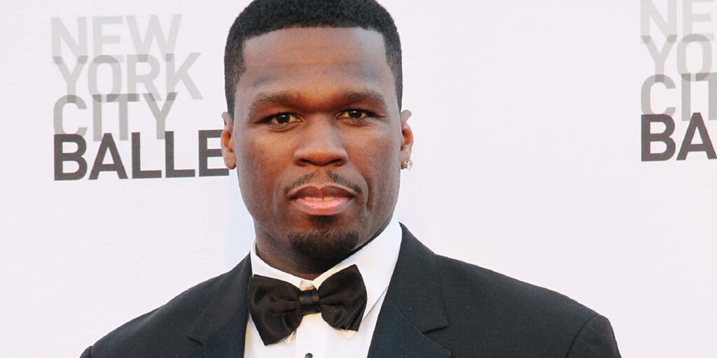 Rapper 50 Cent in black tuxedo exuding confidence style at formal event wallpaper background