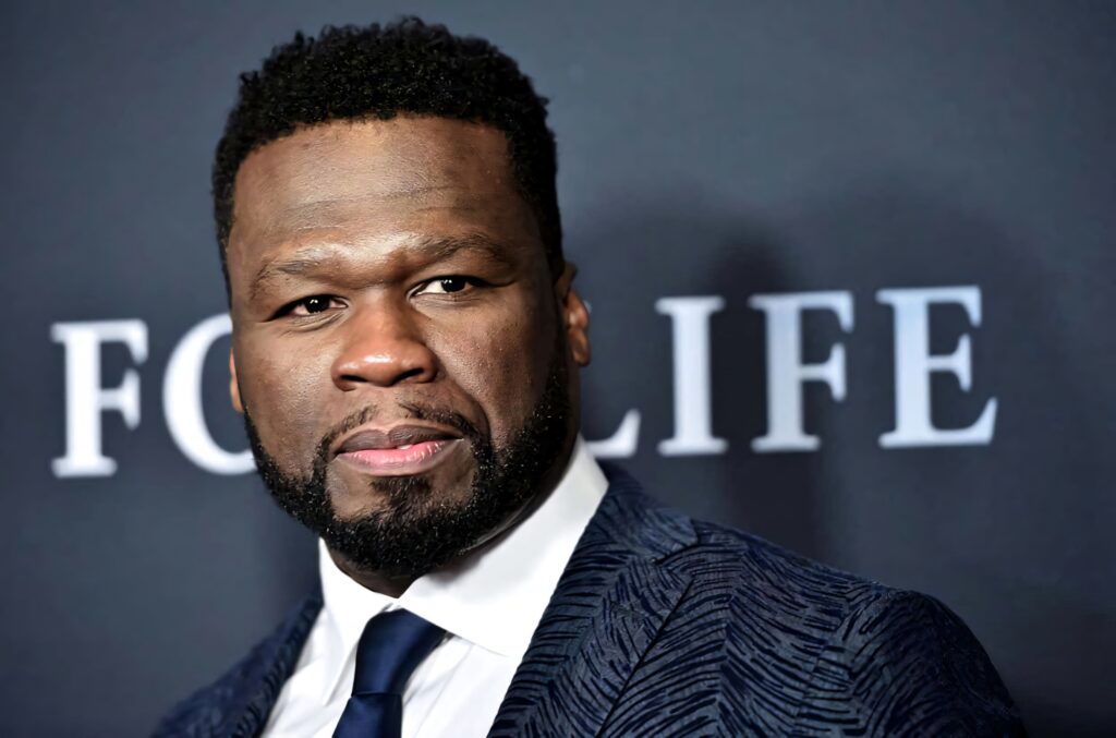 50 Cent confident in suit and tie stylish wallpaper background for rapper fans and hip hop lovers