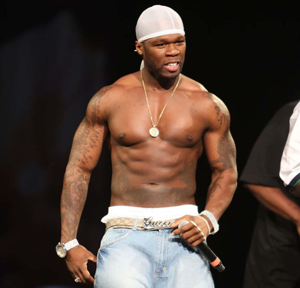 50 Cent performing live on stage showing muscular physique and iconic rapper style wallpaper
