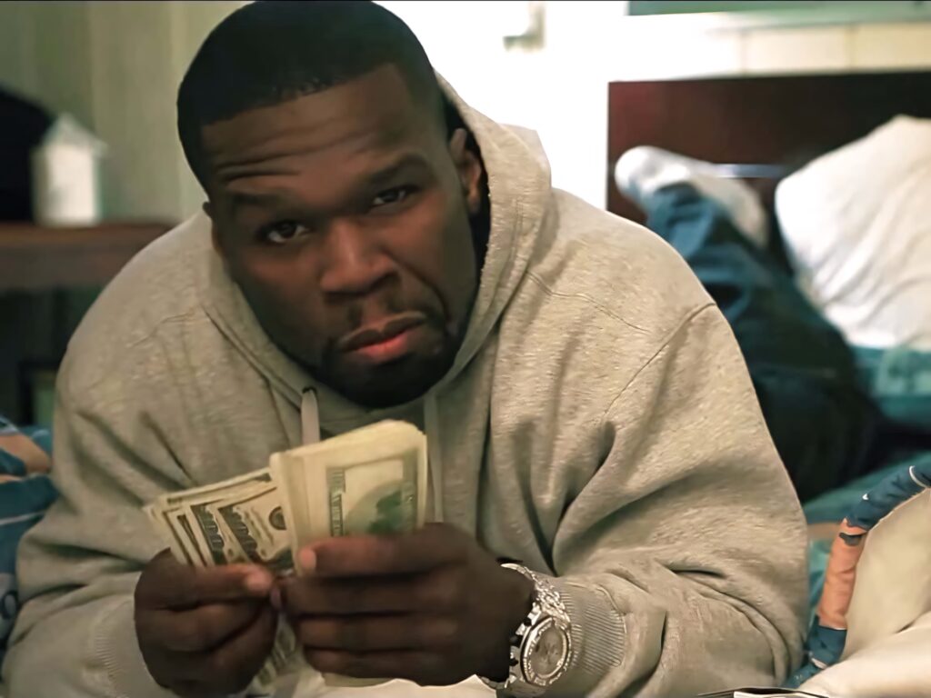 50 Cent lounging on bed wearing gray hoodie holding cash confident rapper style wallpaper