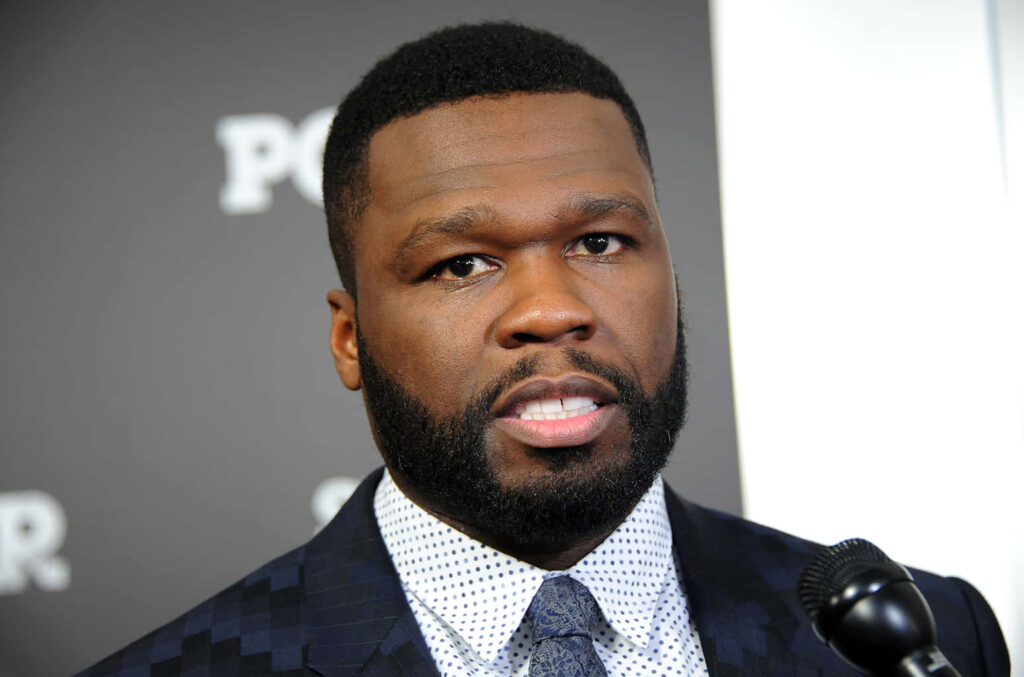 50 Cent in a sharp suit exuding confidence and style iconic hip hop rapper wallpaper background