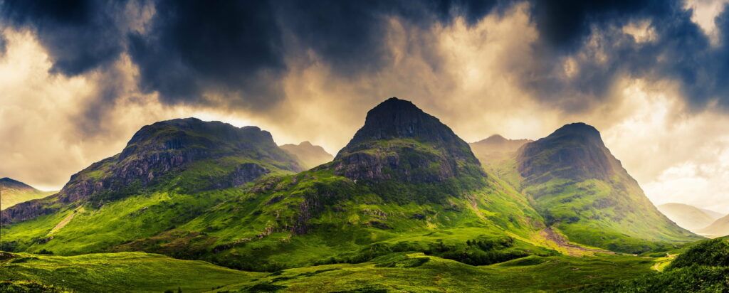 Three Sisters of Glencoe Scottish Highlands green mountains dramatic moody sky wallpaper