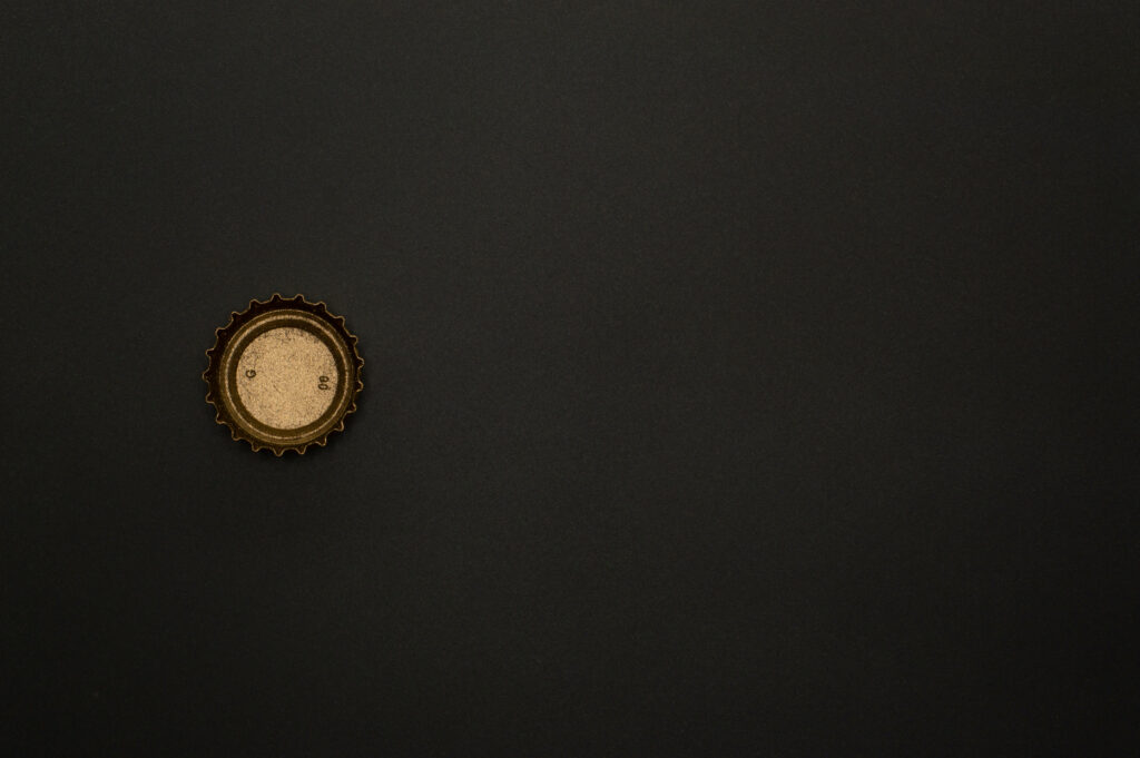 Vintage Vibes: Black and Gold Bottle Cap iPhone Wallpaper