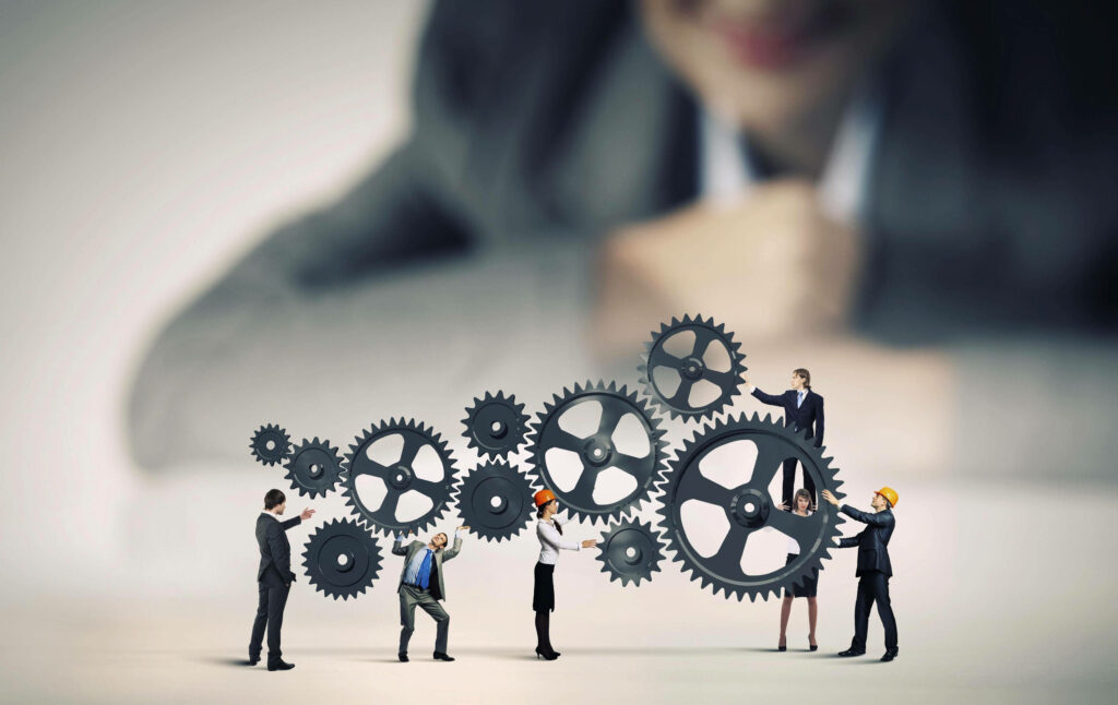 Working in Sync: A Remarkable Business Team Wallpaper with Gears
