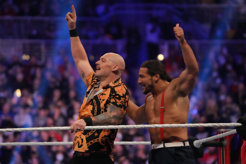 Baron Corbin and John Layfield celebrate in wrestling ring with cheering crowd background wallpaper