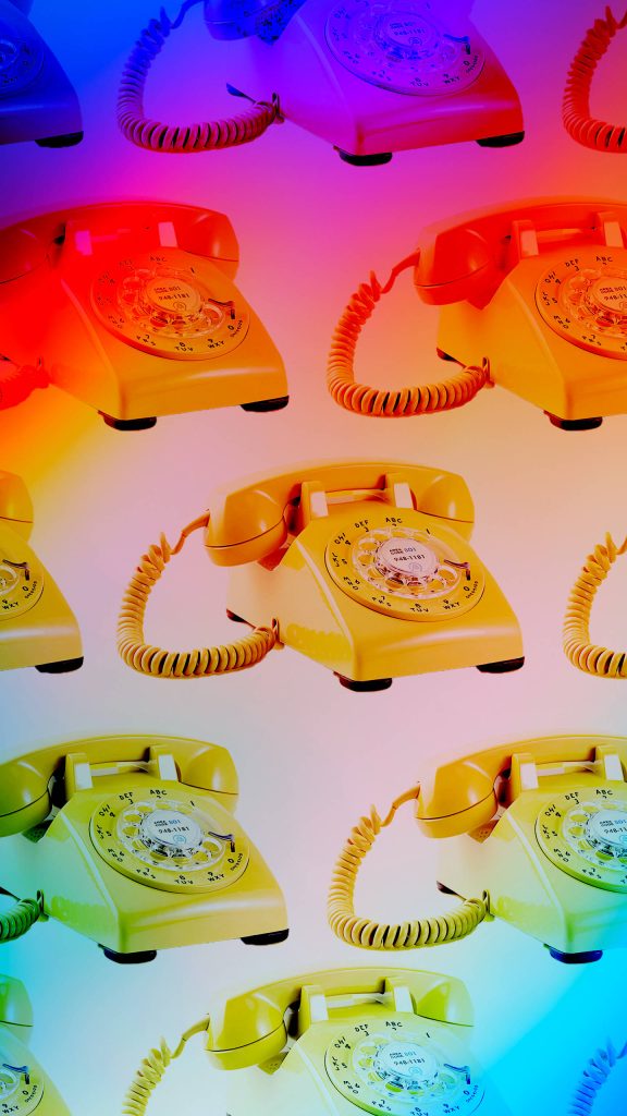 80s retro wallpaper with repeating rotary phones on vibrant neon gradient background desktop design