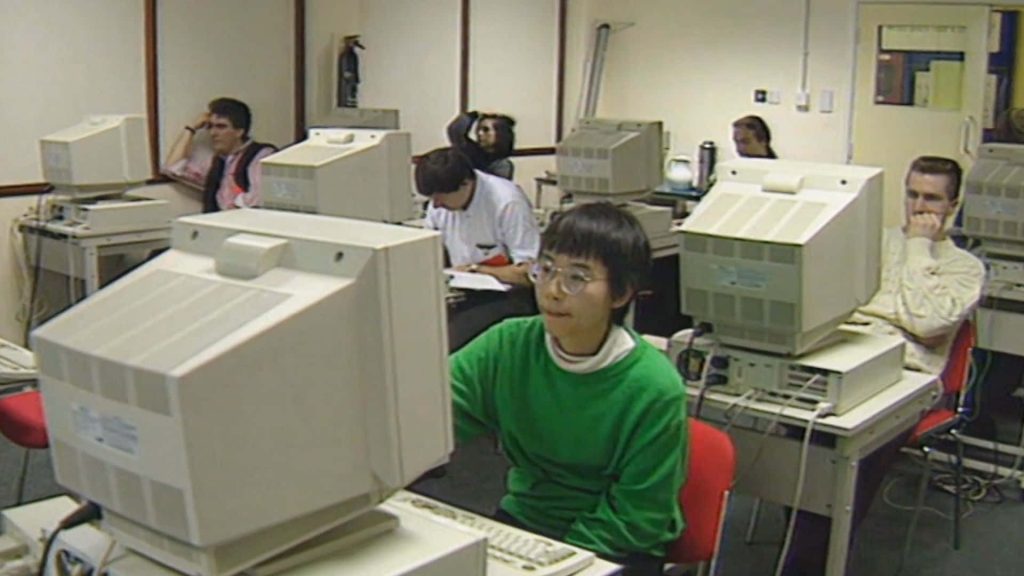 90s computer lab wallpaper vintage CRT monitors student in green sweater retro office scene