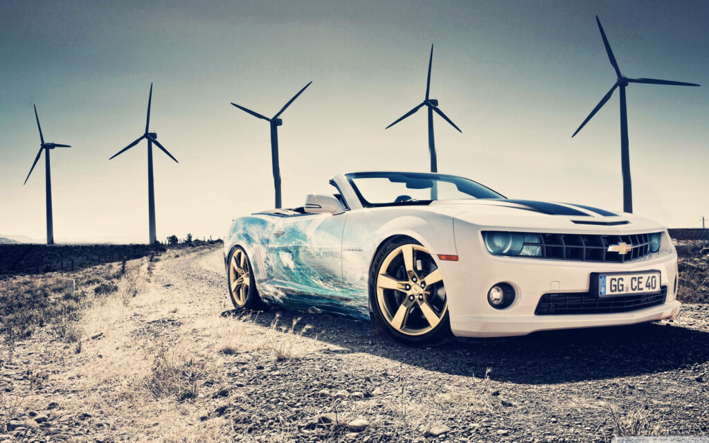 White 2014 Chevrolet Camaro 1LT with golden wheels parked on rural dirt path by windmills sky Wallpaper