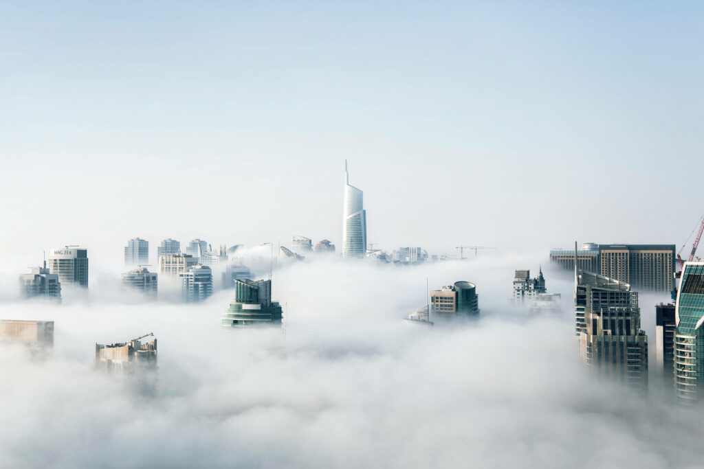 Majestic Metropolis: Immersive Mac 4k Background Showcasing Cloud-Enveloped City Skyscrapers Wallpaper