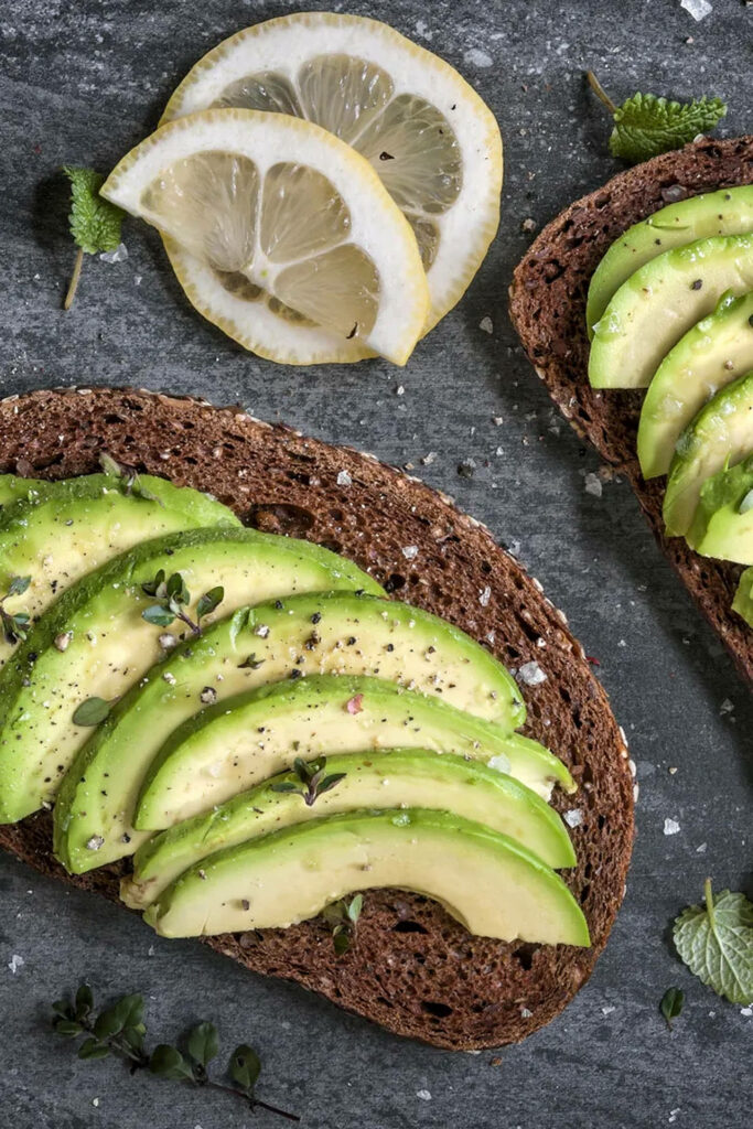 Deliciously Fresh Avocado Sandwich on Rustic Bread, Garnished with Zesty Lemon Slices Wallpaper