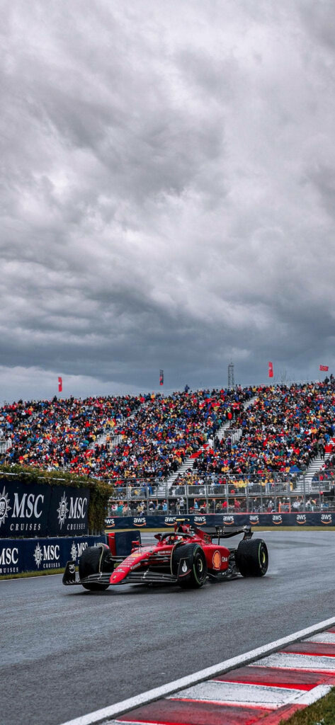 F1's Star Attracts Crowds: Carlos Sainz Jr. Speeding Through Race Spectators Wallpaper