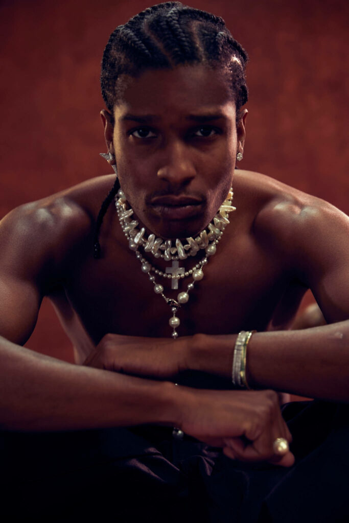 A$AP Rocky shirtless with layered chains intense gaze warm textured background manly style wallpaper