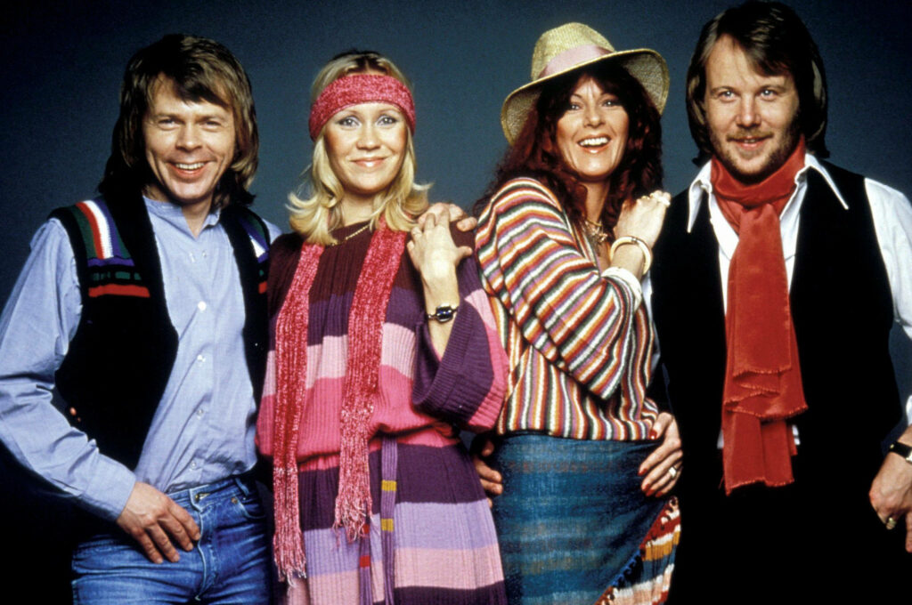 Vibrant ABBA 1977 retro fashion wallpaper with colorful outfits for music and ABBA fans background