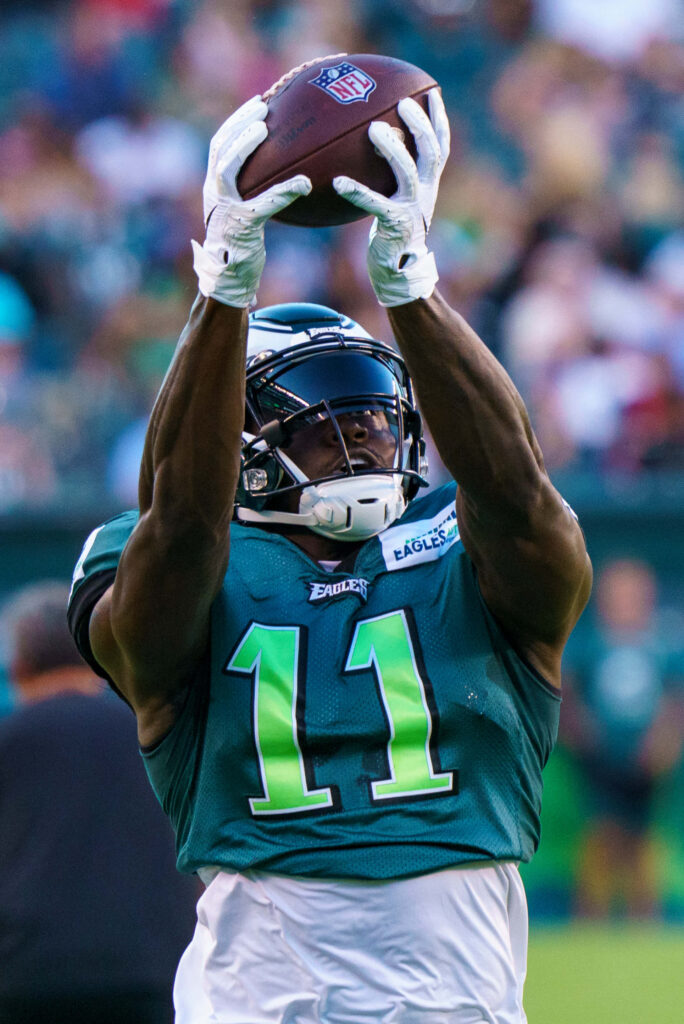 AJ Brown jumps high catching football mid-play showing athleticism and determination wallpaper