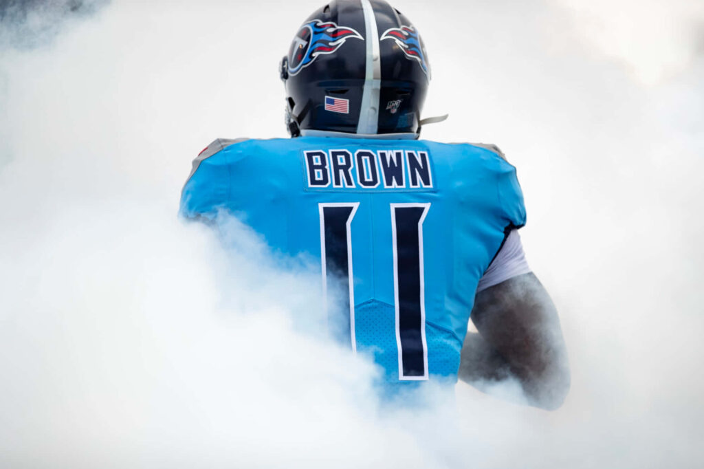 A J Brown walking through thick smoke in Tennessee Titans jersey dramatic football field entrance Wallpaper