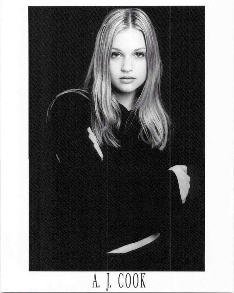 A.J. Cook poised confidently against simple dark wallpaper background portrait photo