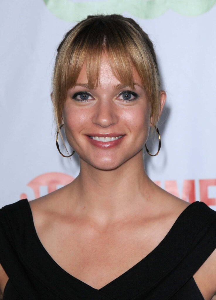A J Cook graceful pose with warm smile elegant wallpaper background for desktop display