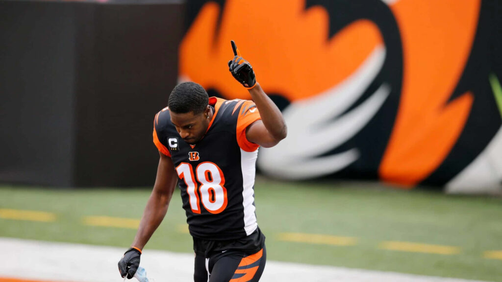AJ Green celebrating in Bengals uniform with raised arm against bold team wallpaper background